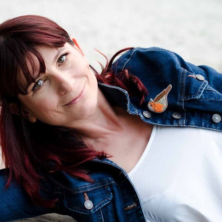 Embroidered robin brooch on a model