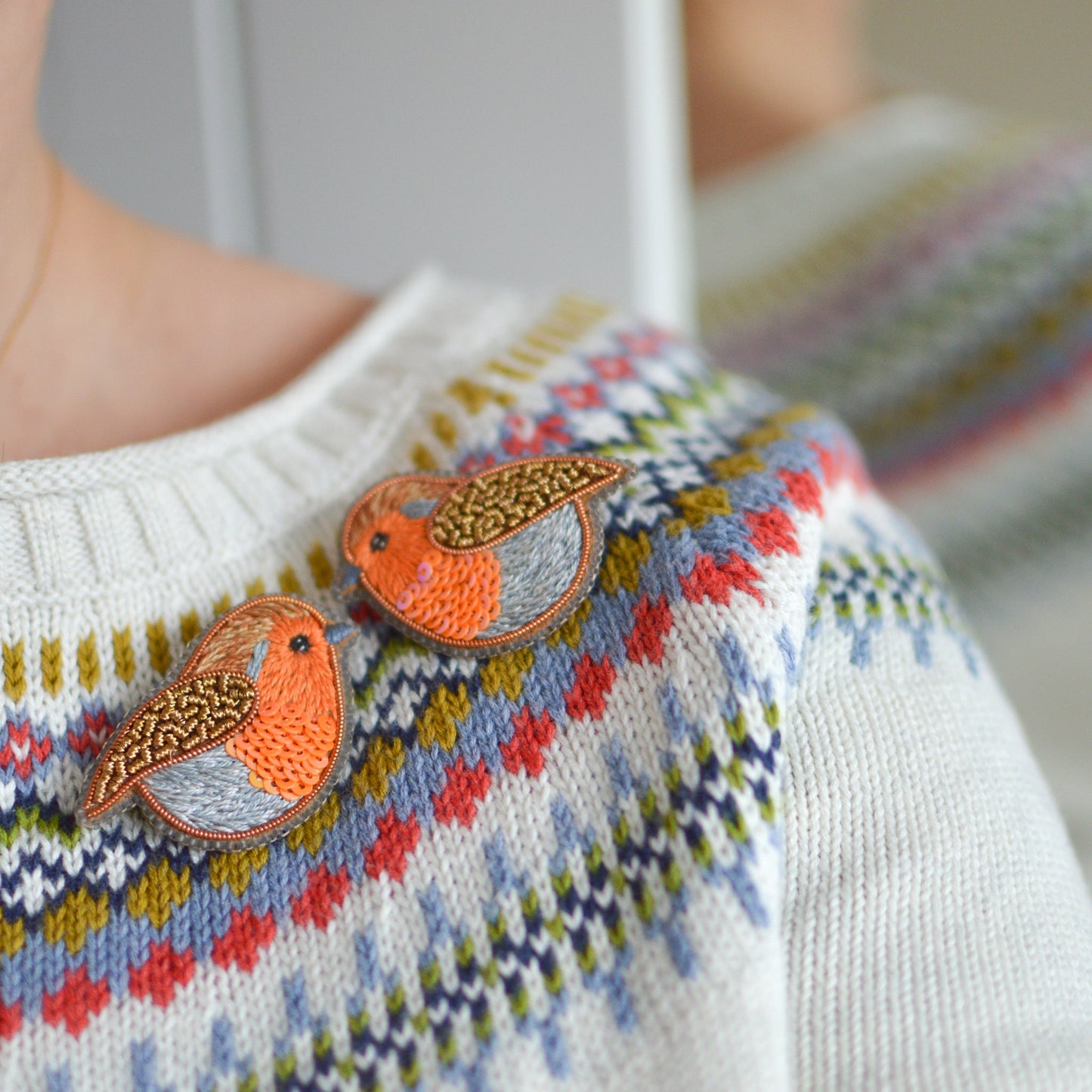 Embroidered robin brooches worn on a jumper