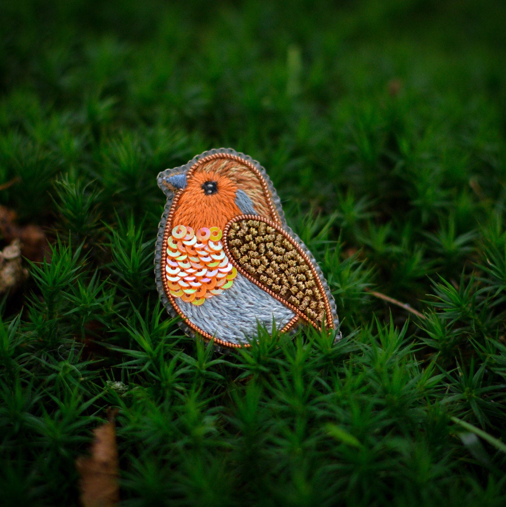 Embroidered robin on moss