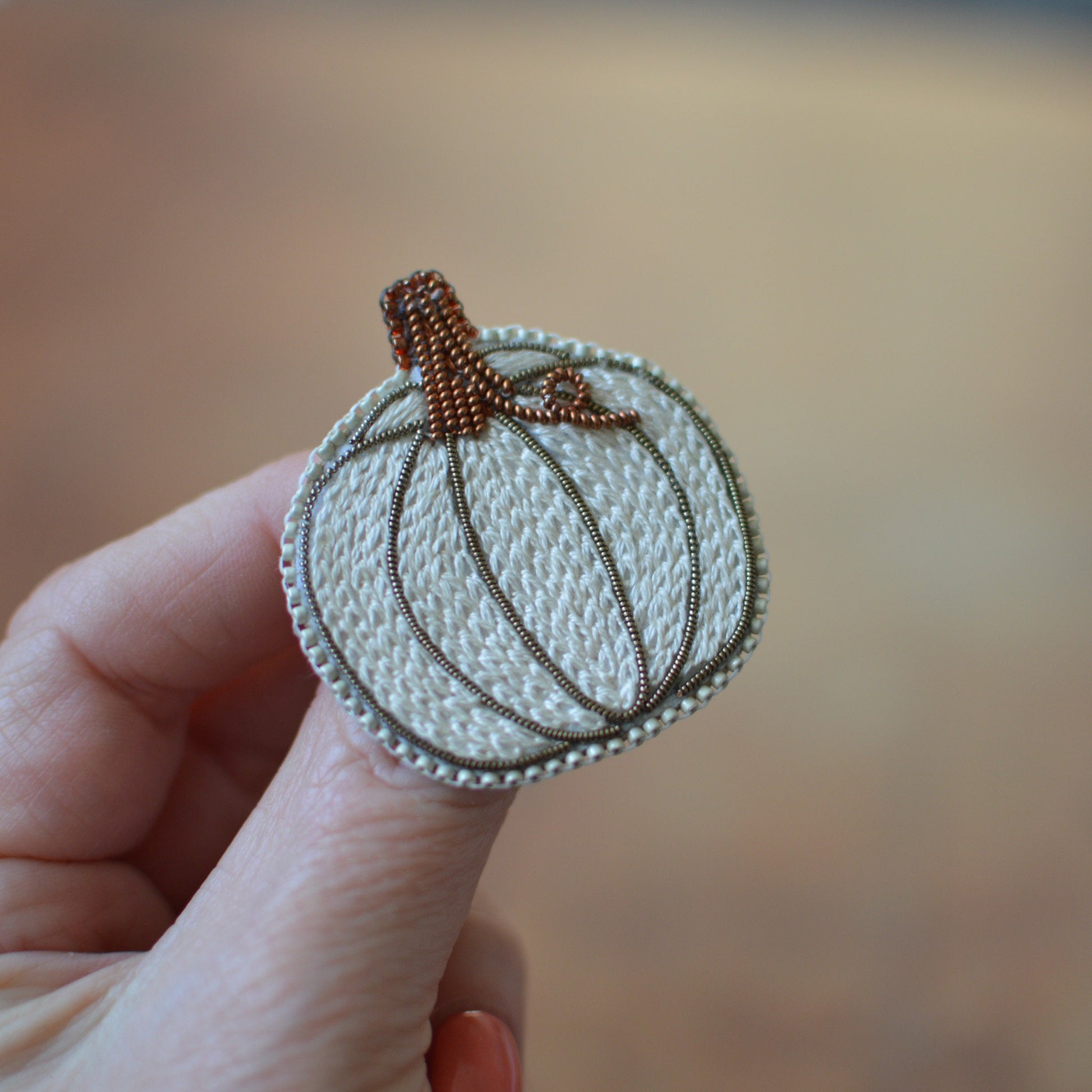 white embroidered pumpkin brooch